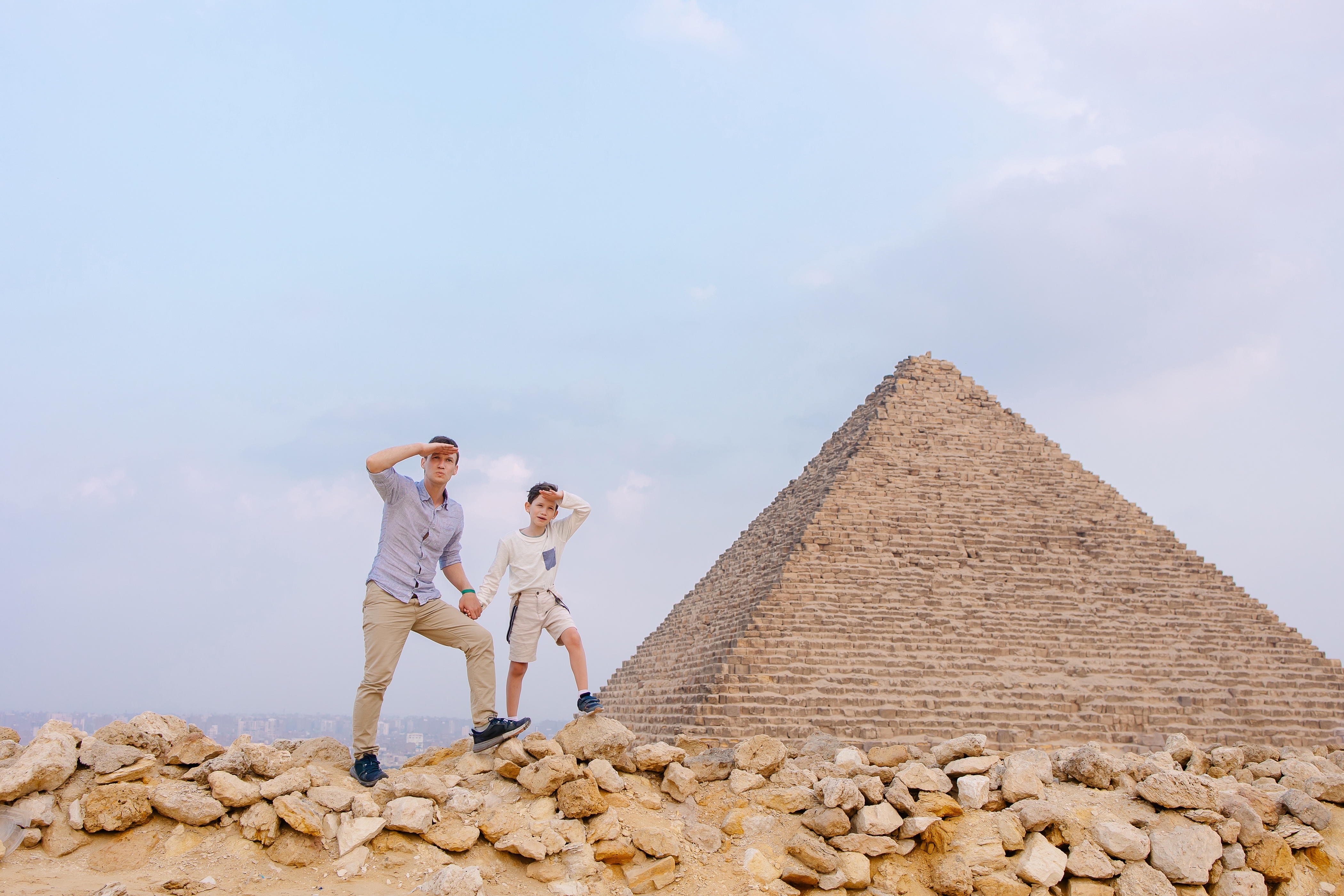 Father and child together in front of the pyramids in Cairo.
